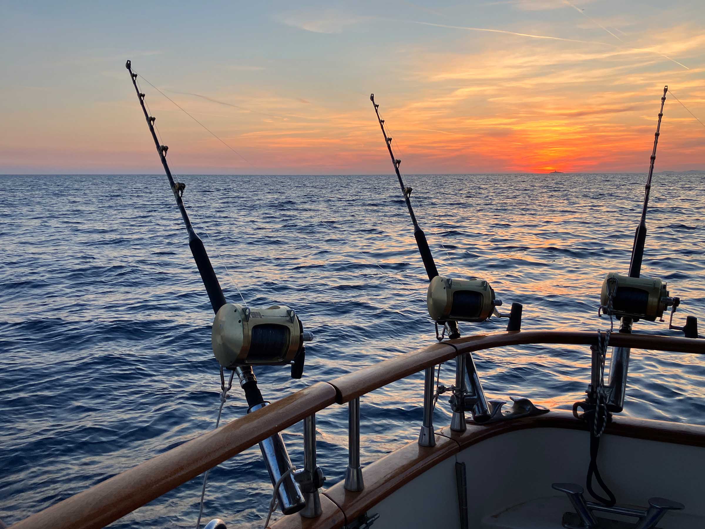 die drei profi biggame angeln ausgefahren im hintergrund sonnenuntergang und das kroatische meer